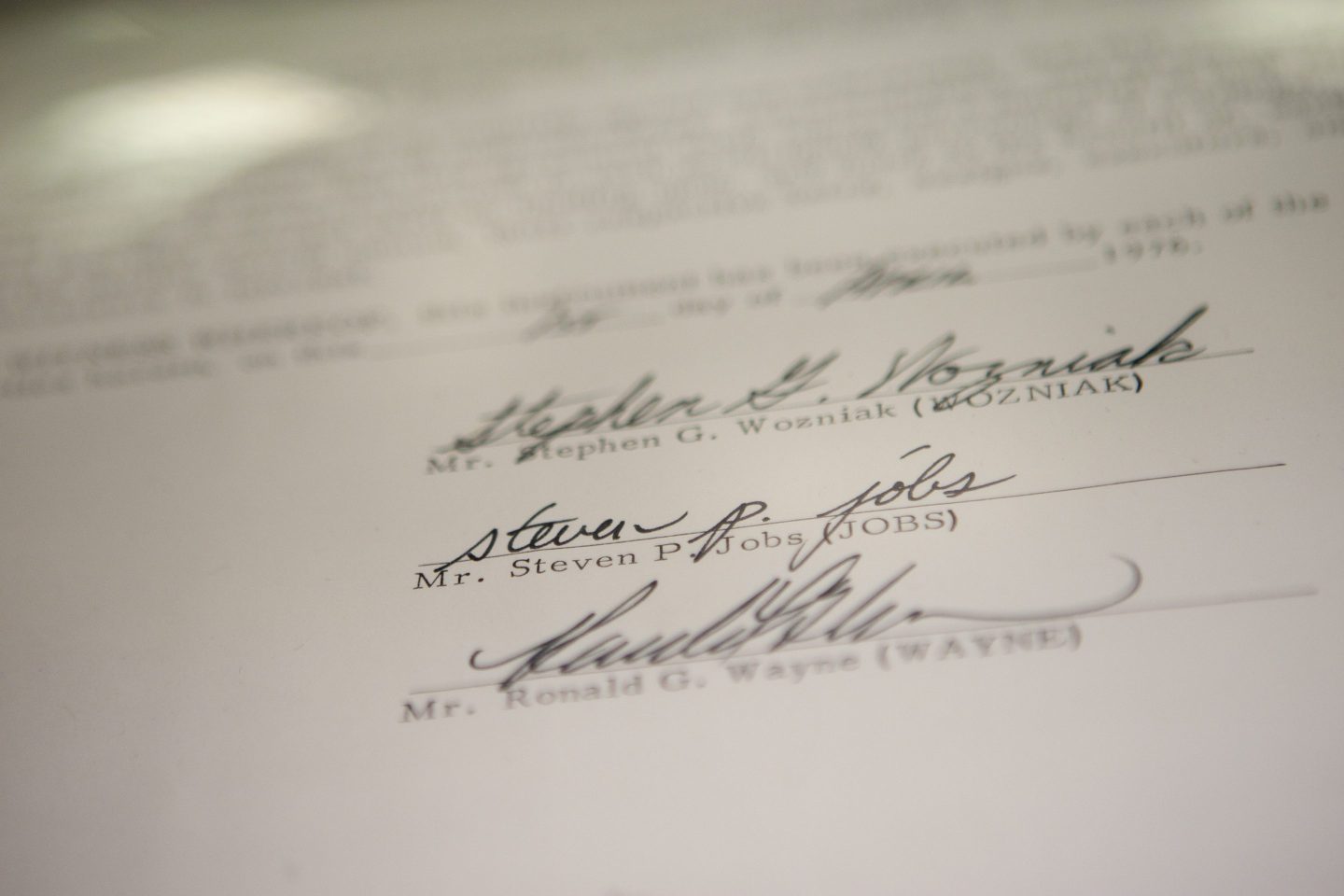 Photo of three signatures at the bottom of a contract
