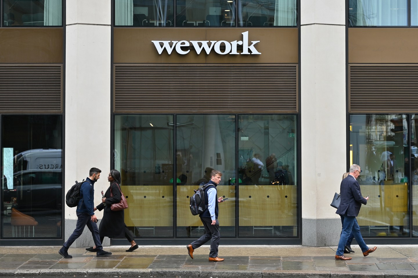 People walk outside of a WeWork office building in London.