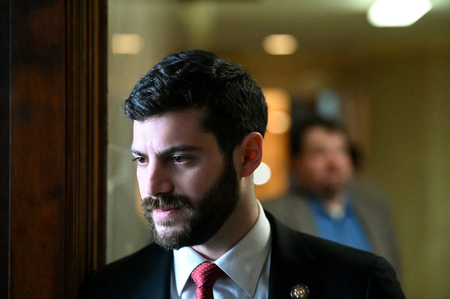 Alex Bores stands near a window in the Capitol building
