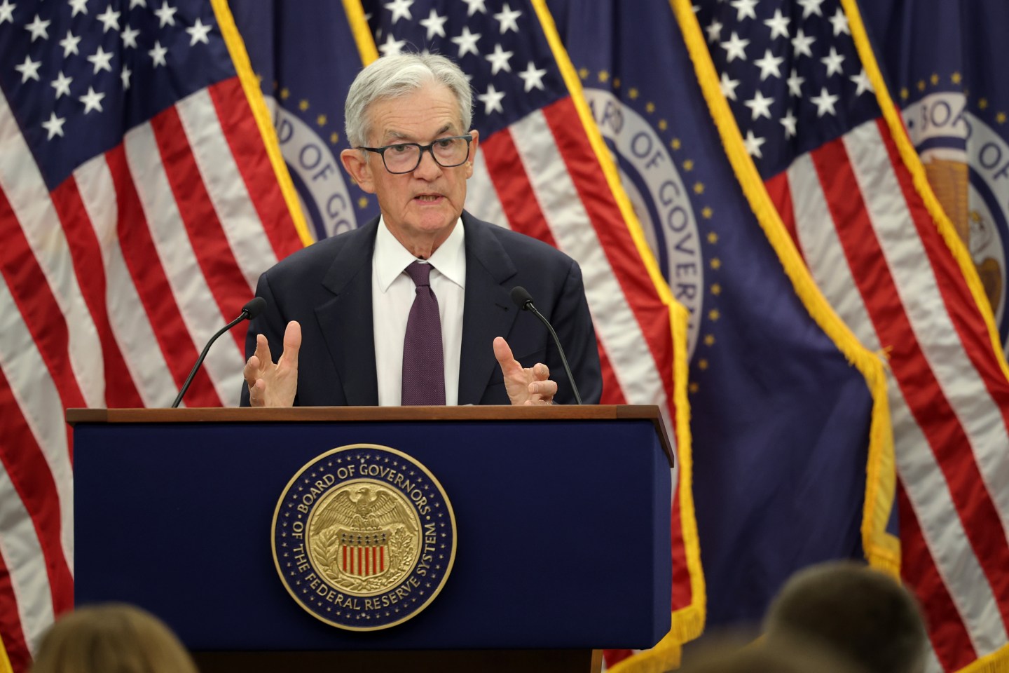 Fed Chair Jerome Powell stands at podium and talks